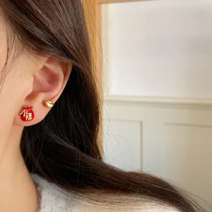 Asymmetric Chinese lucky bag earrings in festive red and gold with Fu character