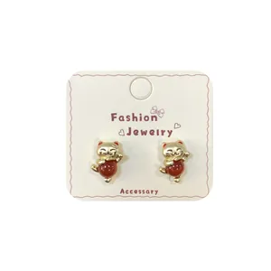 Golden Maneki Neko stud earrings with red beads on fashion jewelry display card