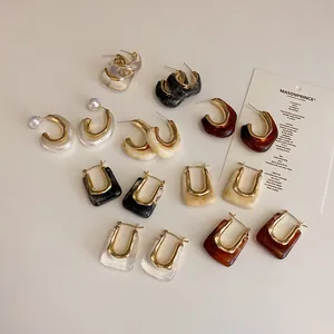 Vintage geometric metal and resin earrings set with pearls on a neutral background