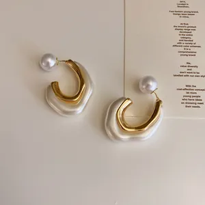 Macro view of French vintage geometric metal and resin earrings with a pearlescent finish