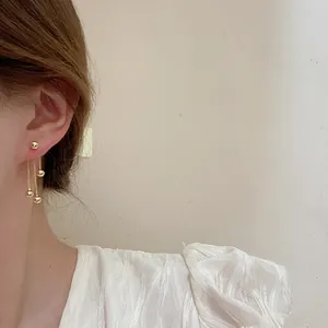 Elegant gold tassel earrings featuring metallic beads and long delicate chain fringes