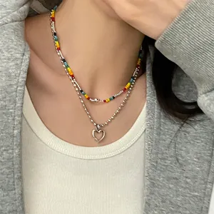 Collier double rang avec perles arc-en-ciel et pendentif cœur argenté sur modèle