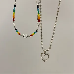 Détail du collier à perles colorées smiley et chaîne à billes avec pendentif cœur