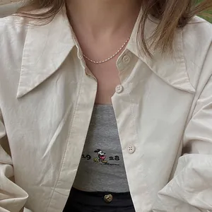 Detailansicht einer silbernen minimalistischen Reiskorn-Halskette getragen zum Outfit
