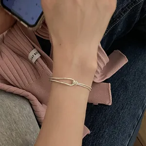 Close-up of a double-layered silver U-shape horseshoe and twist chain bracelet for women
