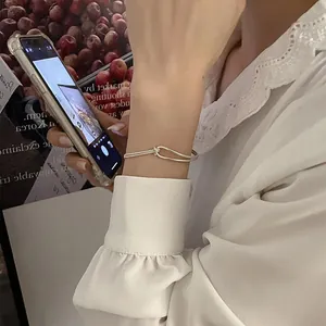 Close-up of minimalist double-layer silver metal hook bracelet on female wrist