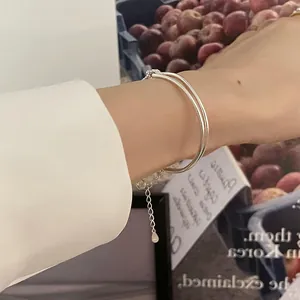 Close-up of double-layer silver bangle with adjustable extension chain on wrist