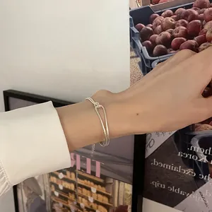 Detail view of a double-layered silver knot bracelet with an adjustable extension chain