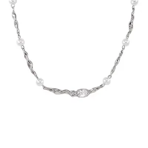 Modern irregular liquid metal necklace with white pearls and central clear oval stone