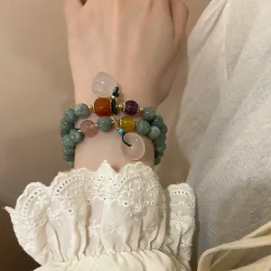 Detailed macro view of vintage beaded bracelet with natural stone and floral pendant charm