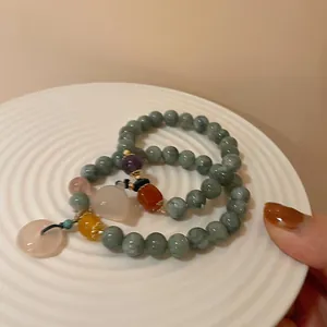 Vintage style jade green beaded bracelets set with colorful gemstones and small pink charm