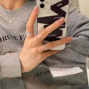 Détail d'une bague argentée multicouche et d'un collier de perles sur un mannequin
