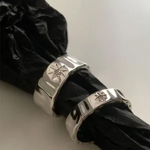 Hammered silver starburst ring with crystal detail on a black textured background