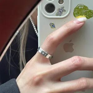 Detail of silver irregular starburst ring with cross star engraving on finger