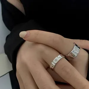 Macro shot of wide irregular hammered silver rings with star pattern and zircons