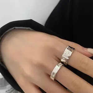Macro shot of silver irregular hammered rings featuring engraved starburst patterns