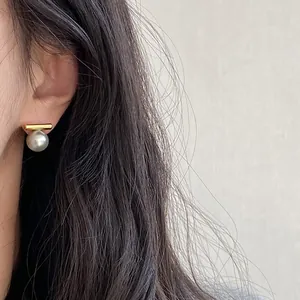 Nahaufnahme der minimalistischen Goldstab-Perlenohrringe am Modell für eleganten Stil