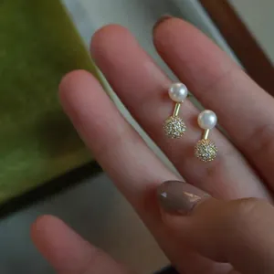 Detail showing freshwater pearls and gold zircon-studded ball earrings in a velvet gift box