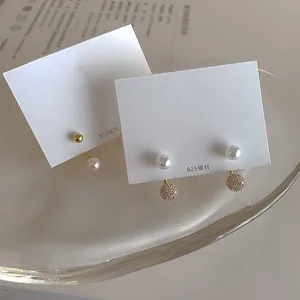 Detailed view of 925 silver needle freshwater pearl earrings with cubic zirconia accents