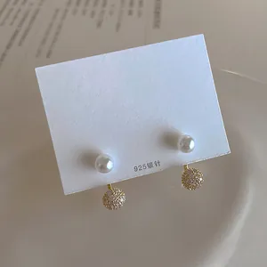 Detail of freshwater pearl earring with 925 silver needle and paved zircon sphere