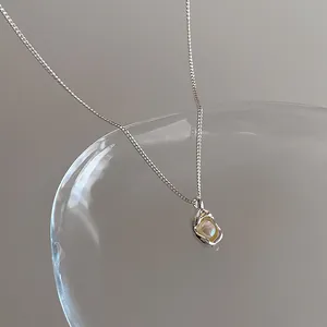 Détail macro d'un collier avec pendentif argenté irrégulier orné d'une perle nacrée