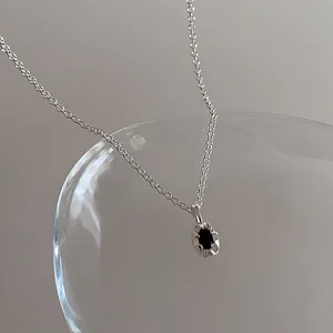 Gros plan d'un collier vintage en argent avec une pierre noire ovale sertie de griffes