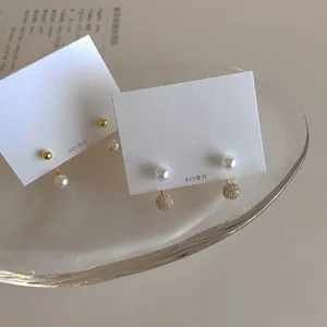 Dual-wear freshwater pearl and zircon earrings set with 925 silver needles in a glass dish