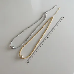 Minimalistische Perlenketten in Silber und Gold, dargestellt mit einem Lineal zur Messung