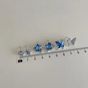 Three pairs of blue zircon earrings featuring star moon butterfly and planet designs