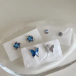 Three-pair earring set with blue star, butterfly, and moon designs in silver and blue