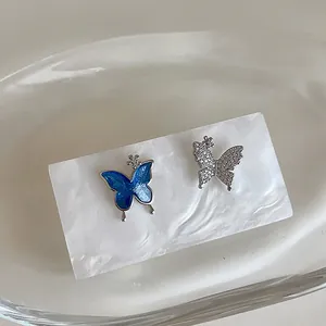 Detail of butterfly stud earrings featuring blue enamel and sparkling pavé zircon stones