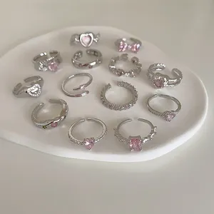 Lot de 13 bagues argentées avec zircons roses en forme de cœur et de nœud