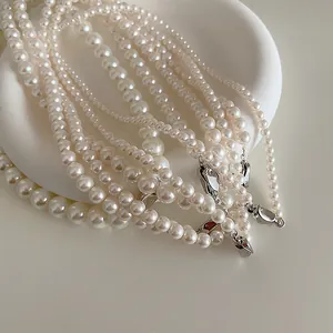 Détail de colliers en perles de verre élégants avec fermoirs argentés sur un plateau
