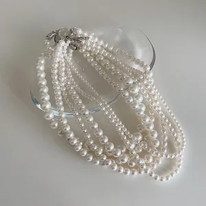 Détail de colliers de perles de verre multi-rangs avec fermoirs en métal sur verre