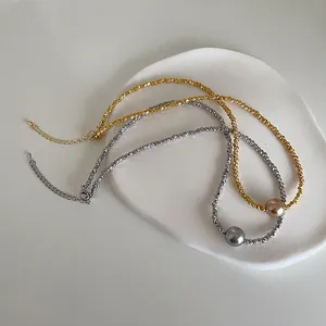 Nahaufnahme minimalistischer Perlenketten mit strukturierten Gold- und Silberketten