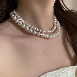 Gros plan sur l'élégant collier de perles de verre double couche aux perles blanc crème