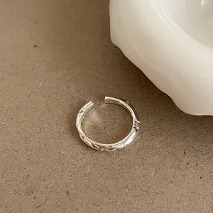 Macro detail of a silver irregular open ring with zircon stones and S925 mark