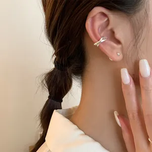 Close-up of minimalist silver double-layer ear cuff and ball stud earring set