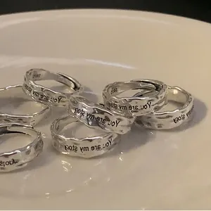 Detail of S925 silver irregular heart rings with hammered texture and engraved lettering