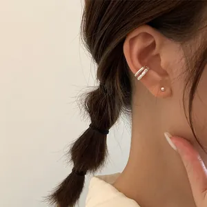 Close-up of double-layered silver ear cuff with smooth and textured metal rings