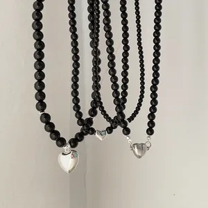 Three-piece black pearl beaded necklaces with silver heart pendants in varying chain widths