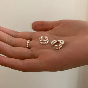 Close-up of silver-tone irregular double-layer ear cuffs and pig nose anchor chain rings