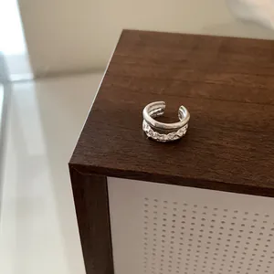 Detail of S925 sterling silver ear cuff with irregular hammered texture and smooth band