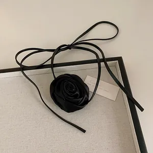 Close-up of handmade black satin rose choker necklace with thin lace-up ribbon ties