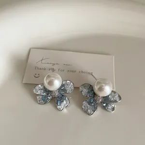 Macro shot of blue gradient crystal flower earrings with a centered white pearl