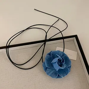 Detail of blue denim camellia flower necklace with multi-layer handcrafted petals