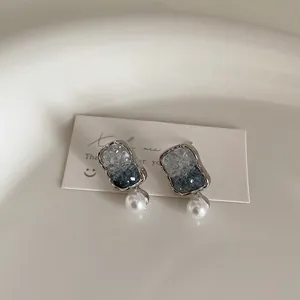 Detail of blue gradient crystal rectangle earrings with a single white round pearl drop
