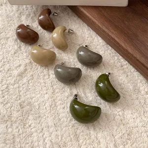 Vue détaillée de boucles d'oreilles demi-cercles en résine en quatre couleurs terre