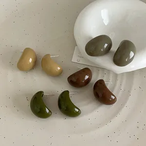 Boucles d'oreilles vintage en résine aux tons terreux sur un plateau en céramique