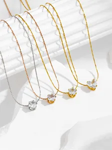 Detailed view of four minimalist zircon pendant necklaces in gold, silver and rose gold